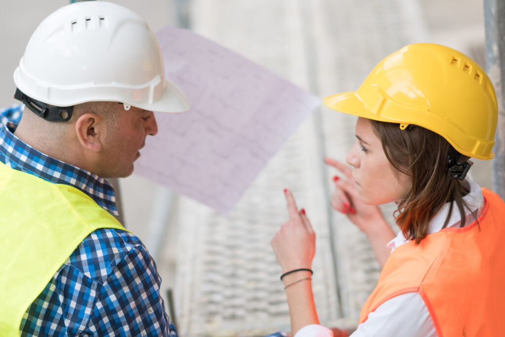 back,turned,technician,and,architect,at,construction,site,reviewing,office